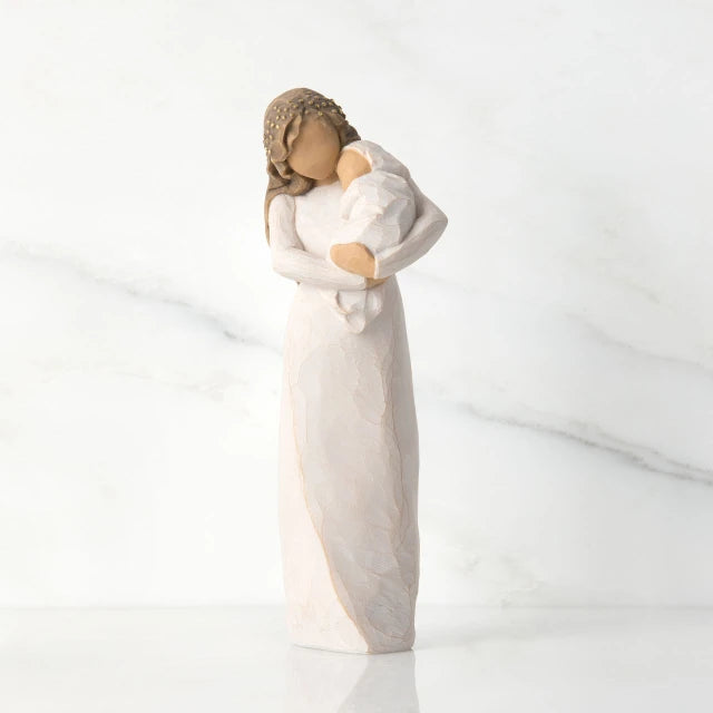 Willow Tree® Front view of brunette woman figurine in white dress holding swaddled baby