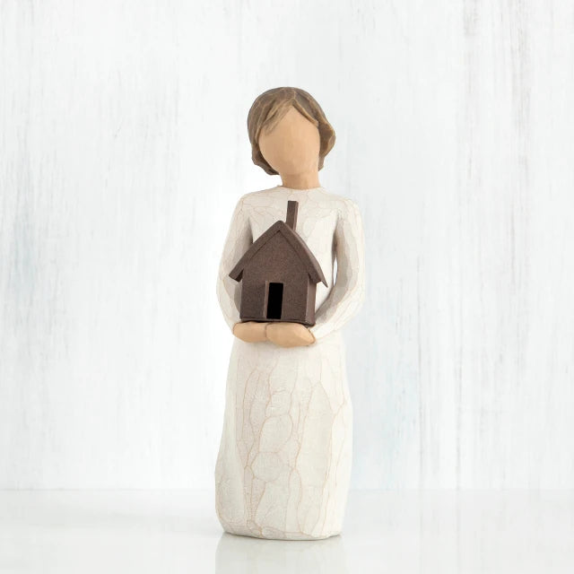 Willow Tree® Faceless girl figurine facing forward wearing white dress, holding brown house figurine in her arms