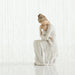 Willow Tree® Faceless mother figurine sitting down holding baby - all wearing white and all white background