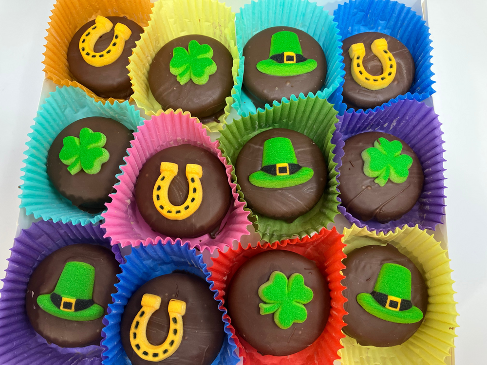 Assorted chocolate candies with lucky charms in colorful paper cups on a white background