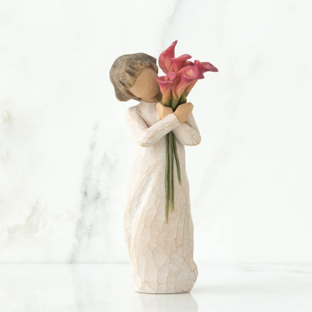 Willow Tree® Front view of little girl with short brown hair holding a cluster of red calla lilies