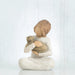 Willow Tree® Front view of young girl with light brown hair sitting cross legged and holding a brown cat in her arms, both cat and girl gaze at each other