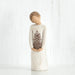 Willow Tree® Front view of girl with brown hair in a bun holding a pineapple with both hands