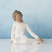 Willow Tree® Faceless woman figurine in white dress sitting don on her knees - blue background