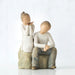 Willow Tree® Young faceless girl figurine sitting on rock next to young facless boy figurine sitting on rock