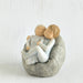 Willow Tree® Two faceless baby figurines hugging one another on grey bean bag figurine