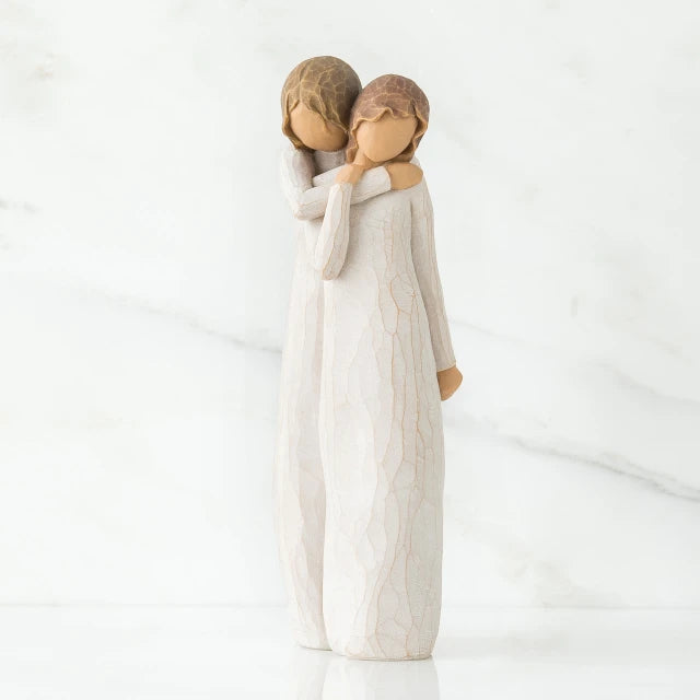 Willow Tree® Two faceless woman figurines standing wearing white dresses hugging one another