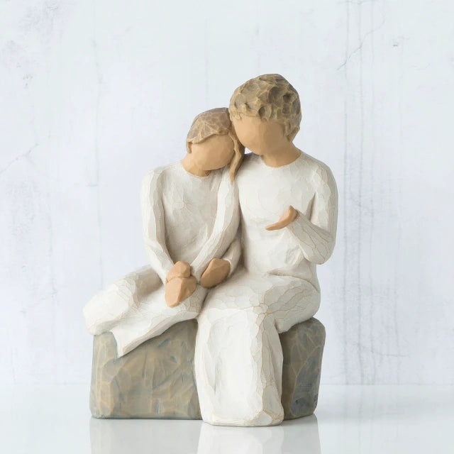 Willow Tree® Two faceless figurines wearing white sitting next to each other on rock