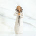 Willow Tree® Close view of blonde woman figurine in white dress holding black flower boquet