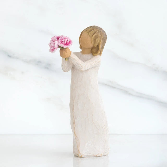 Willow Tree® Front side view of girl with light brown hair holding out pink flowers with both hands