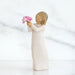 Willow Tree® Front side view of girl with light brown hair holding out pink flowers with both hands