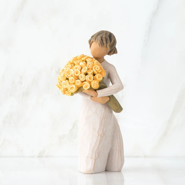 Willow Tree® Front/side view of little girl with short brown hair holding a large bouquet of yellow roses