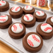 Baseball-themed chocolate-covered Oreos on a tray with a candy kitchen background
