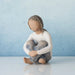 Willow Tree® Faceless young girl figurine wearing white shirt and blue jeans sitting with her hands on her knees