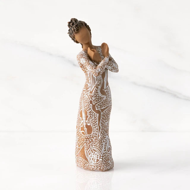 Willow Tree® Front view: Darker-skin figure carved with contrasting pattern of white musical symbols, instruments, dancing forms