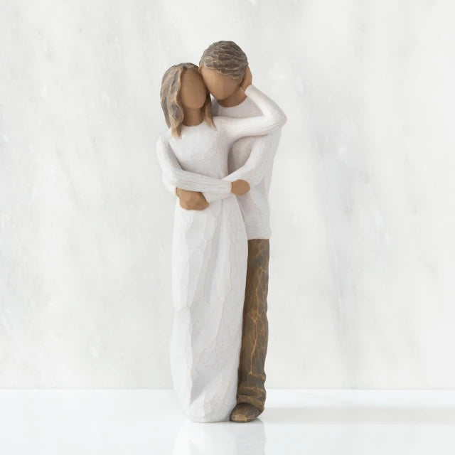 Willow Tree® Front view of couple, standing with arms around each other. Woman and man have darker skin tones and hair color.