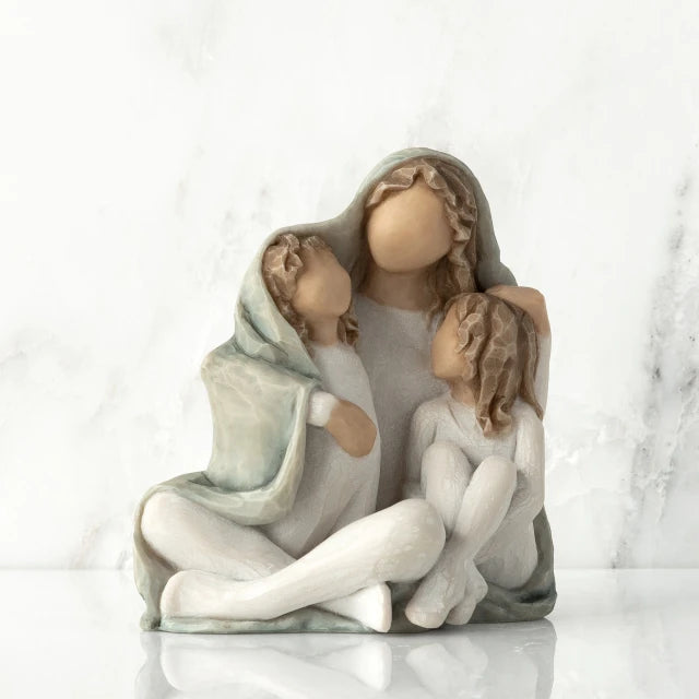Willow Tree® Front View: seated figure with arms around two younger figures, all wrapped in a blue-gray blanket