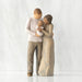 Willow Tree® Front view of standing couple, woman has darker skin and hair; man has lighter skin and hair, holding a baby between them.