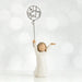 Willow Tree® Front view of little girl with brown hair and both arms in the air as she holds a wire balloon. Text on balloon is wire