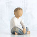 Willow Tree® Small little boy figurine sitting down faceless, wearing white shirt and blue jeans