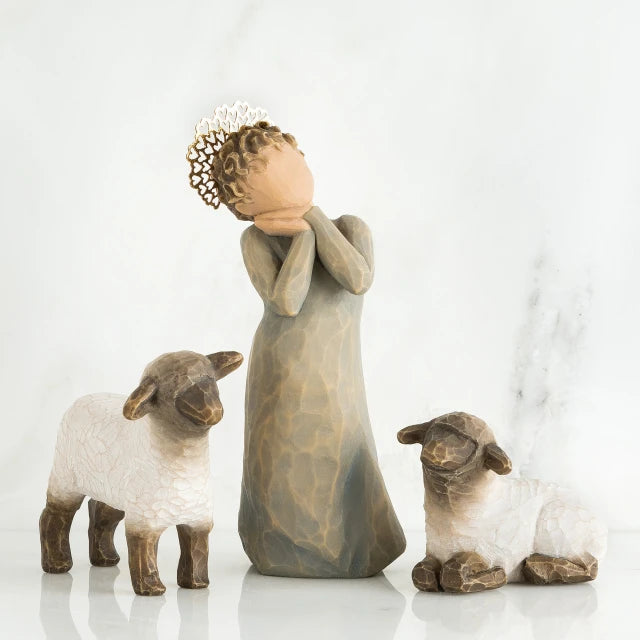 Willow Tree® Angel faceless figurine wearing grey dress with hands on her face in between two white lamb figurines