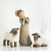 Willow Tree® Angel faceless figurine wearing grey dress with hands on her face in between two white lamb figurines
