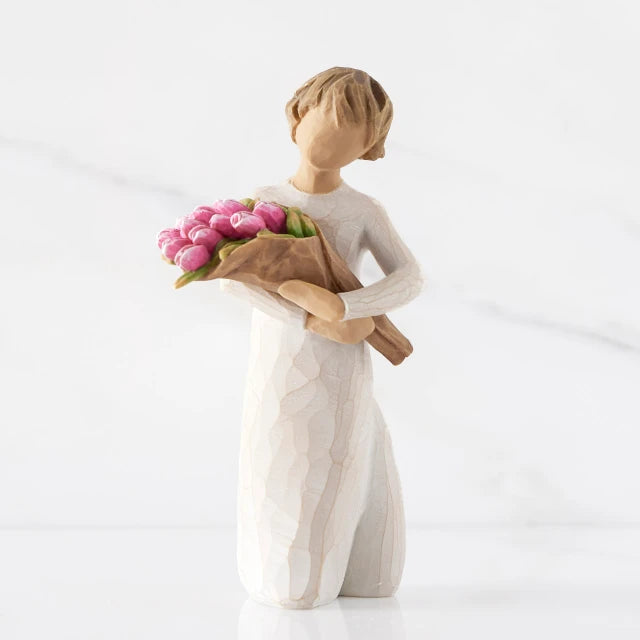 Willow Tree® Front view of standing figure in cream dress holding bouquet of pink tulips