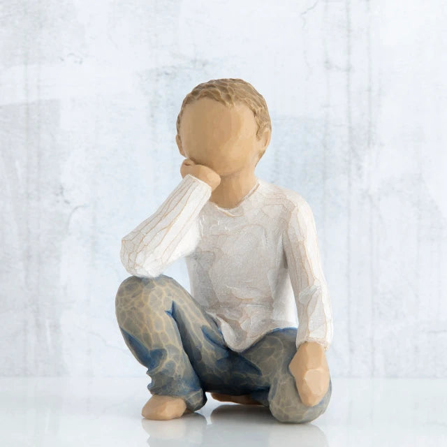 Willow Tree® Small faceless boy figurine sitting with elbow on knee - wearing white shirt and blue jeans