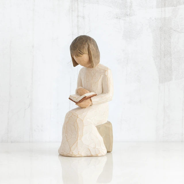 Willow Tree® Young faceless girl figurine in white sitting on rock reading an open book