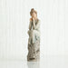 Willow Tree® Woman figurine with brown hair in a bun and in white/blue dress sitting on grey printed rock