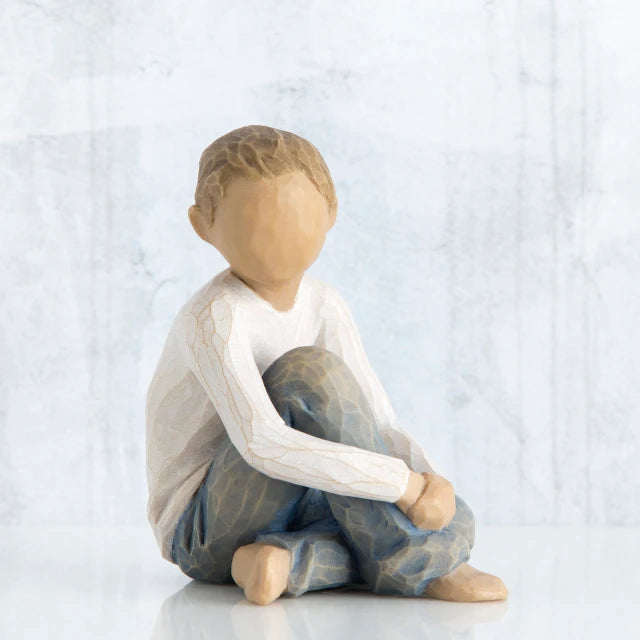 Willow Tree® Little boy figurine sitting with hands over knees - faceless - wearing white shirt and blue jeans