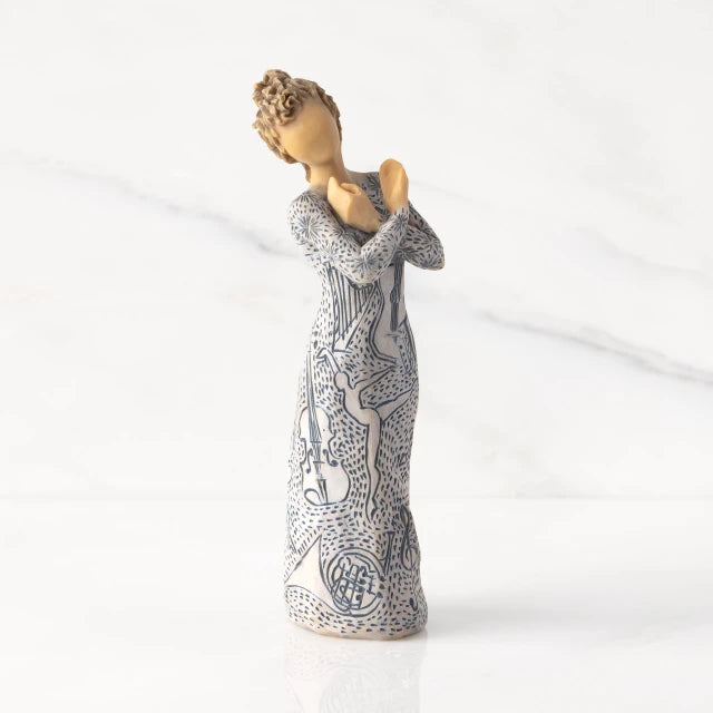 Willow Tree® Front view: Lighter-skin figure carved with contrasting pattern of dark blue musical symbols, instruments, dancing forms